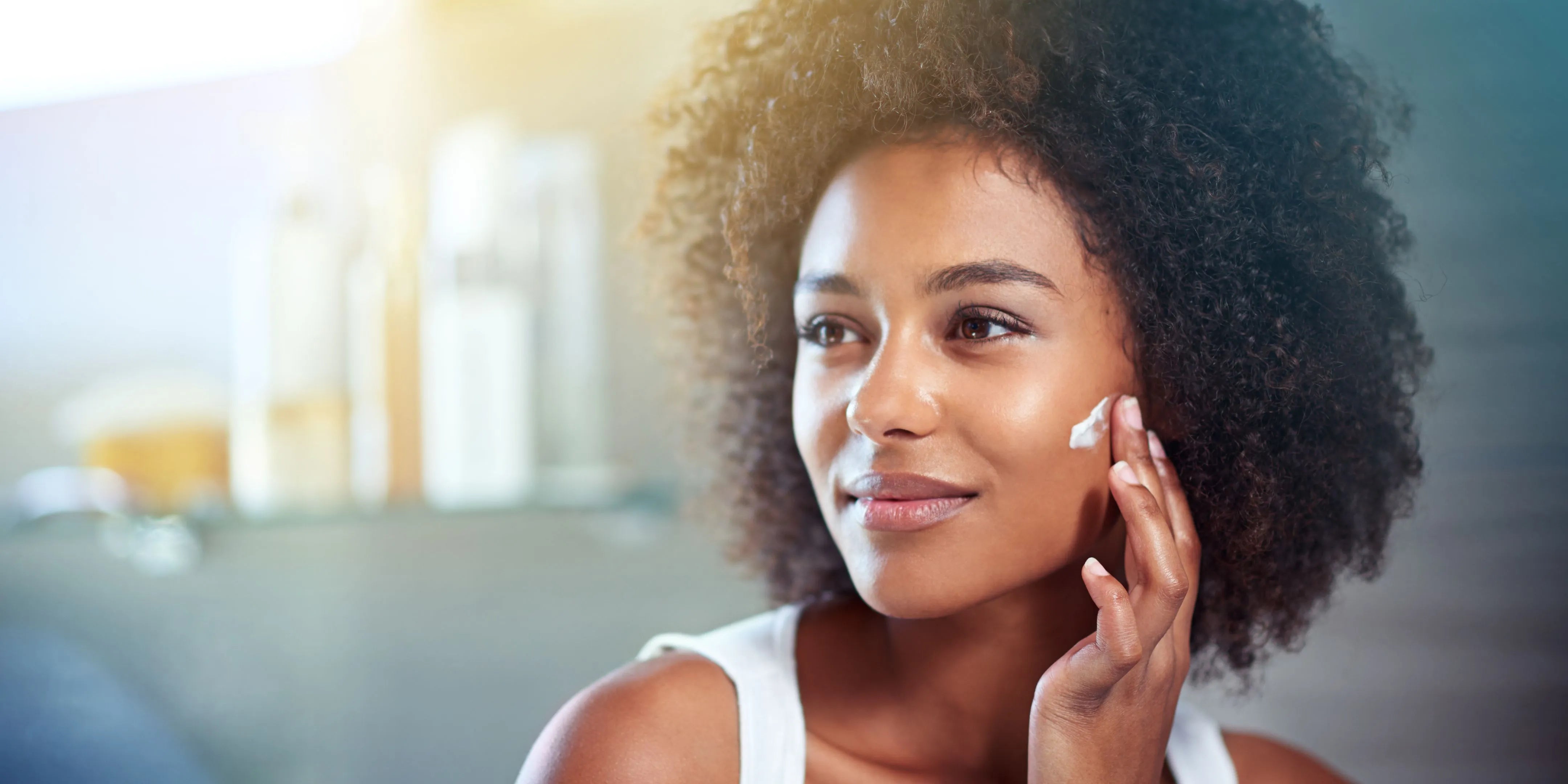 A woman applying cleanser to her oily skin, showcasing effective skincare techniques for a fresh complexion.
