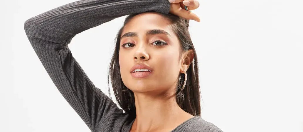 A person applying sunscreen to their skin outdoors, showcasing effective sun protection for healthy skin.