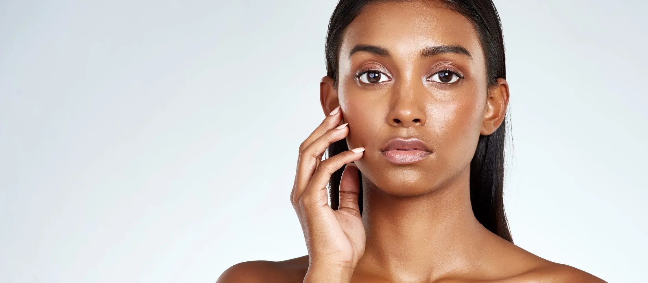 A woman applying oil-free sunscreen to her face, ideal for oily skin and acne prevention.