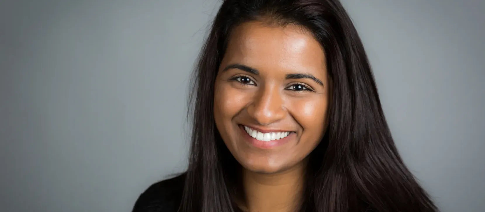 A woman applying pigmentation serum to her face for radiant, glowing skin.