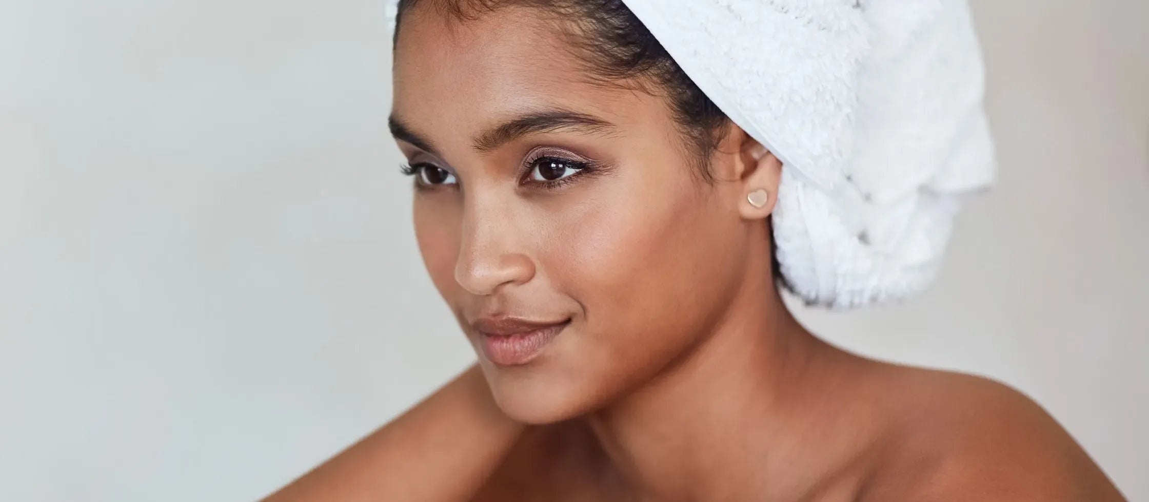 A woman applying lightweight sunscreen on her oily skin, showcasing essential tips for sun protection.