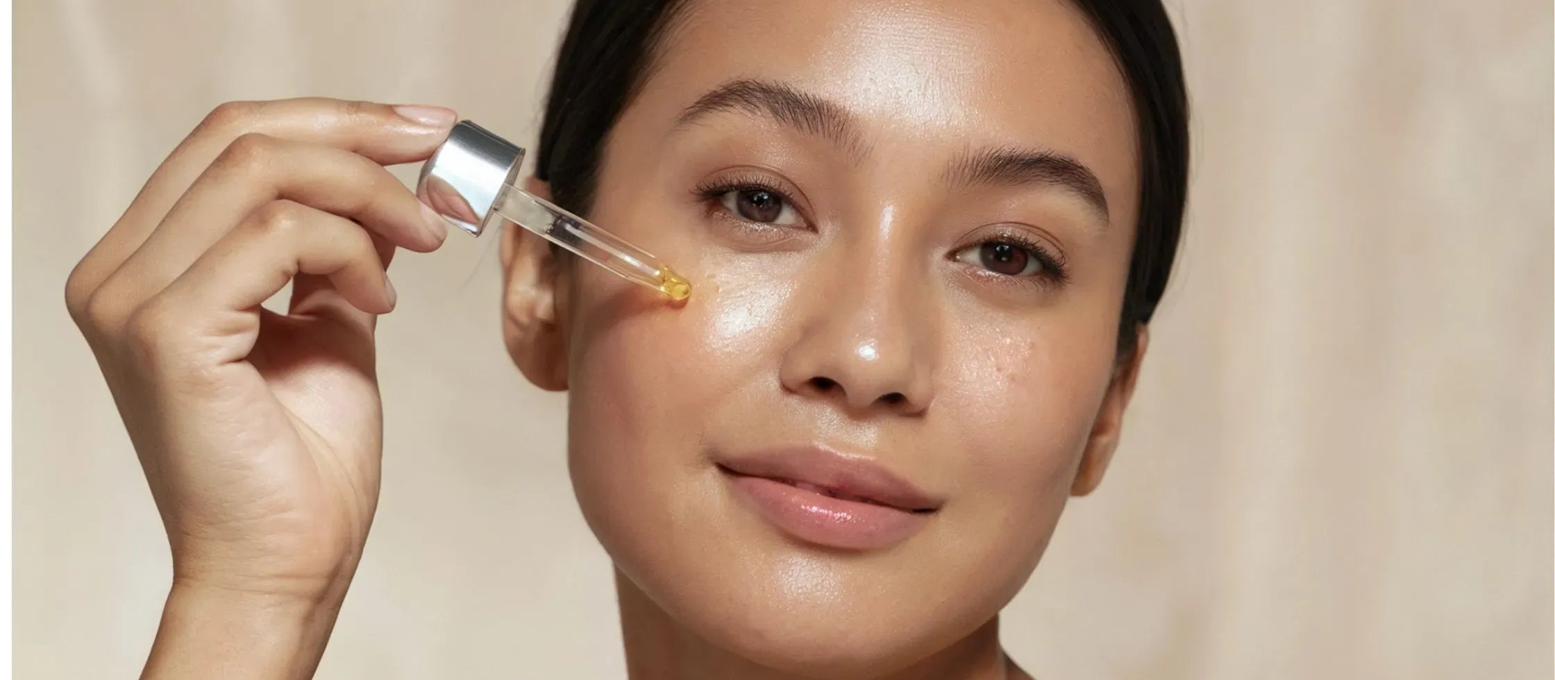 A woman applying pigmentation serum to her dry skin, showcasing a radiant and glowing complexion.