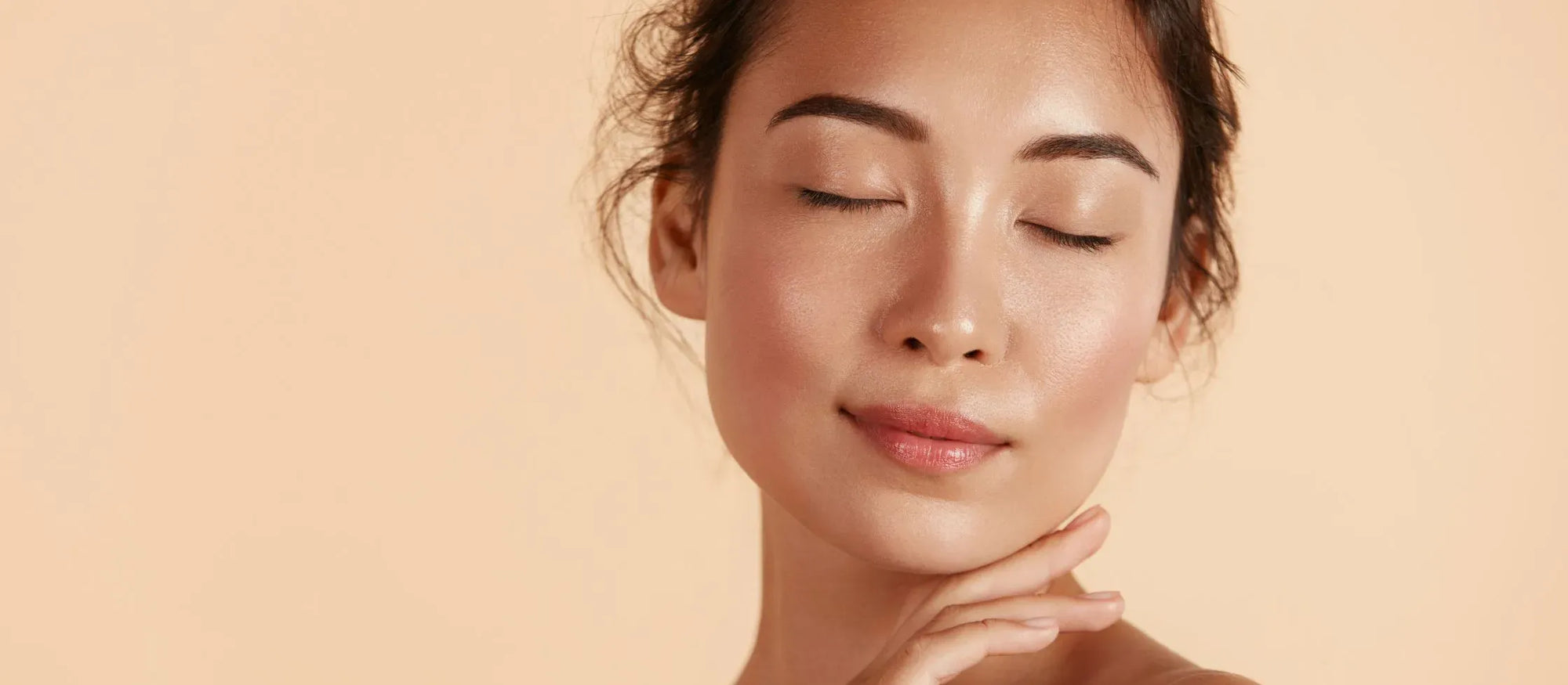 A woman applying serum to her face, targeting hyperpigmentation for a clearer complexion.