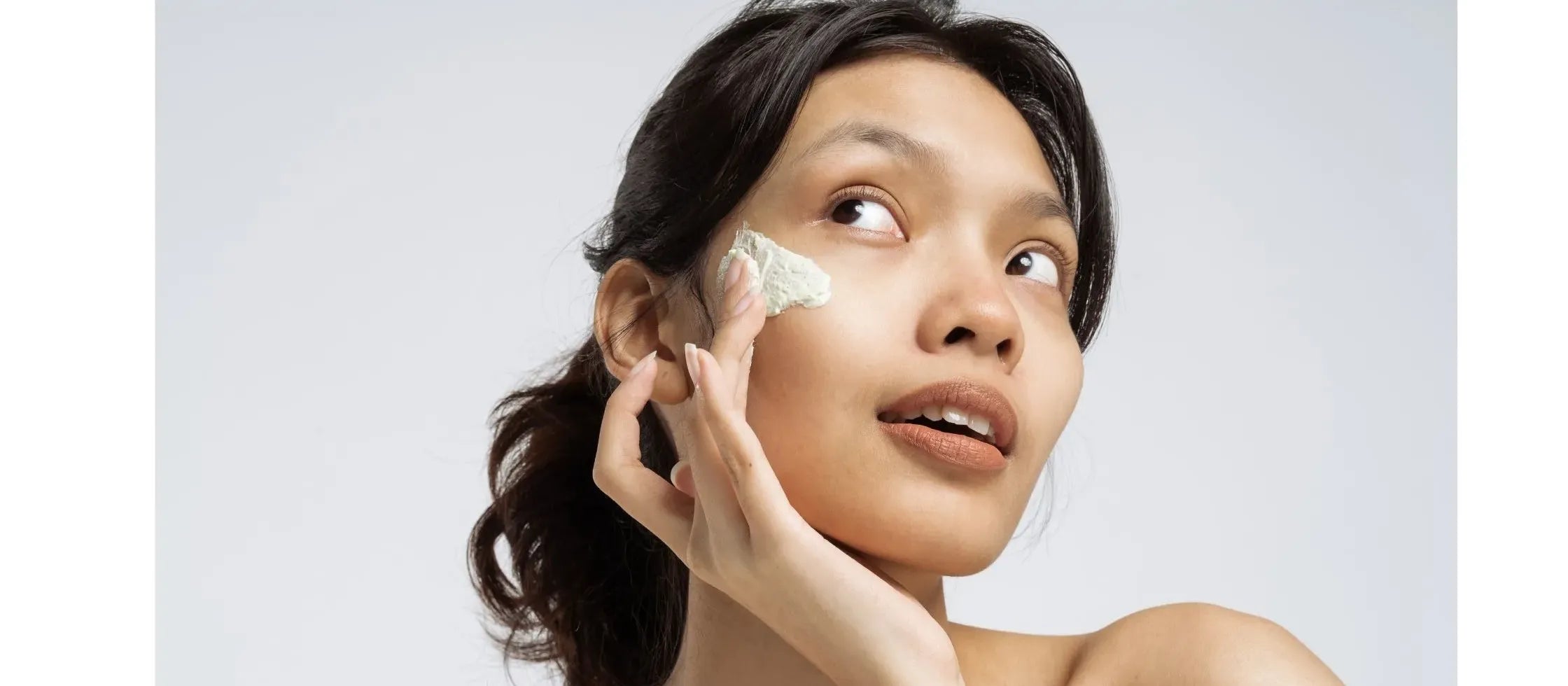 A woman applying gel-based sunscreen on her combination skin, showcasing a lightweight and hydrating formula.