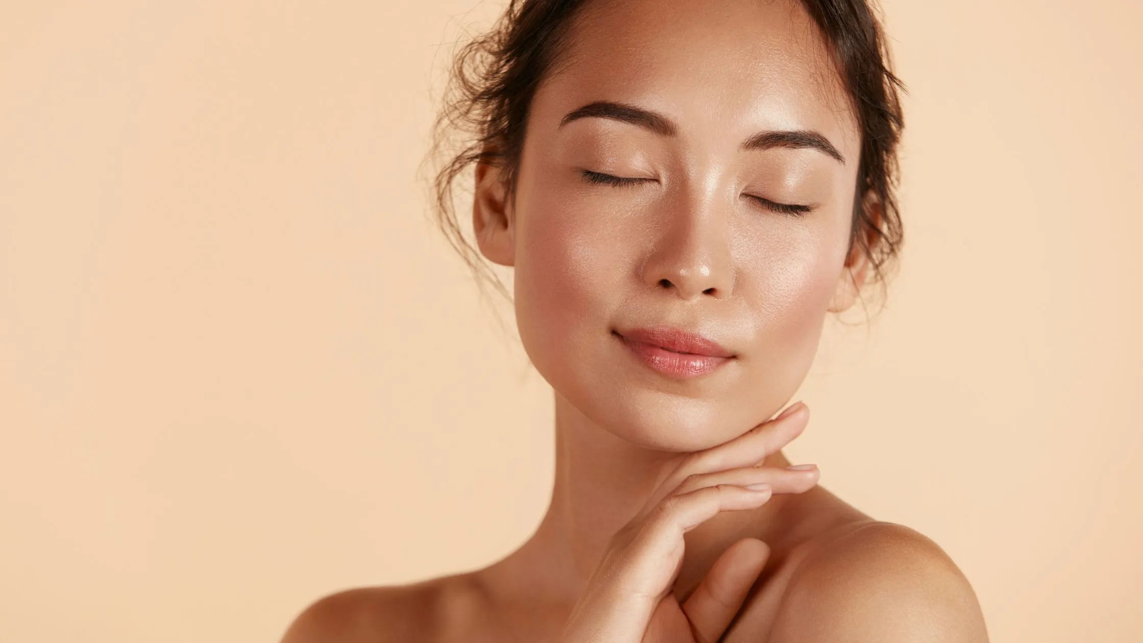 A woman applying a pigmentation serum to her face, showcasing radiant, glowing skin and a youthful appearance.