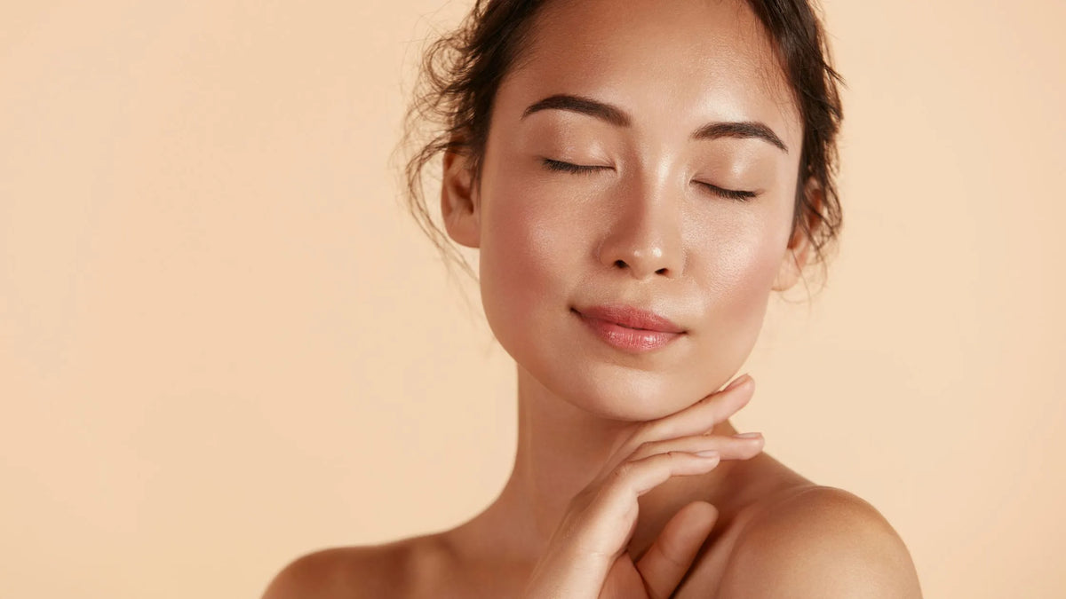A woman applying a pigmentation serum to her face, showcasing radiant, glowing skin and a youthful appearance.