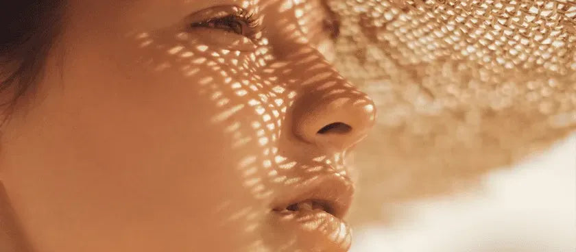 A person applying salicylic acid sunscreen to their face, highlighting its skin benefits and sun protection.
