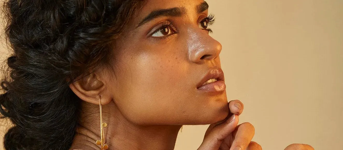 A person applying a gentle face wash to clear pimples and dark spots for a radiant complexion.