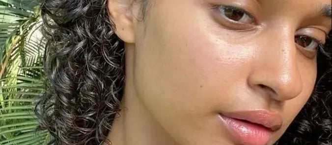 A bottle of sunscreen for dry skin placed beside a sunhat and sunglasses, highlighting essential skincare tips.