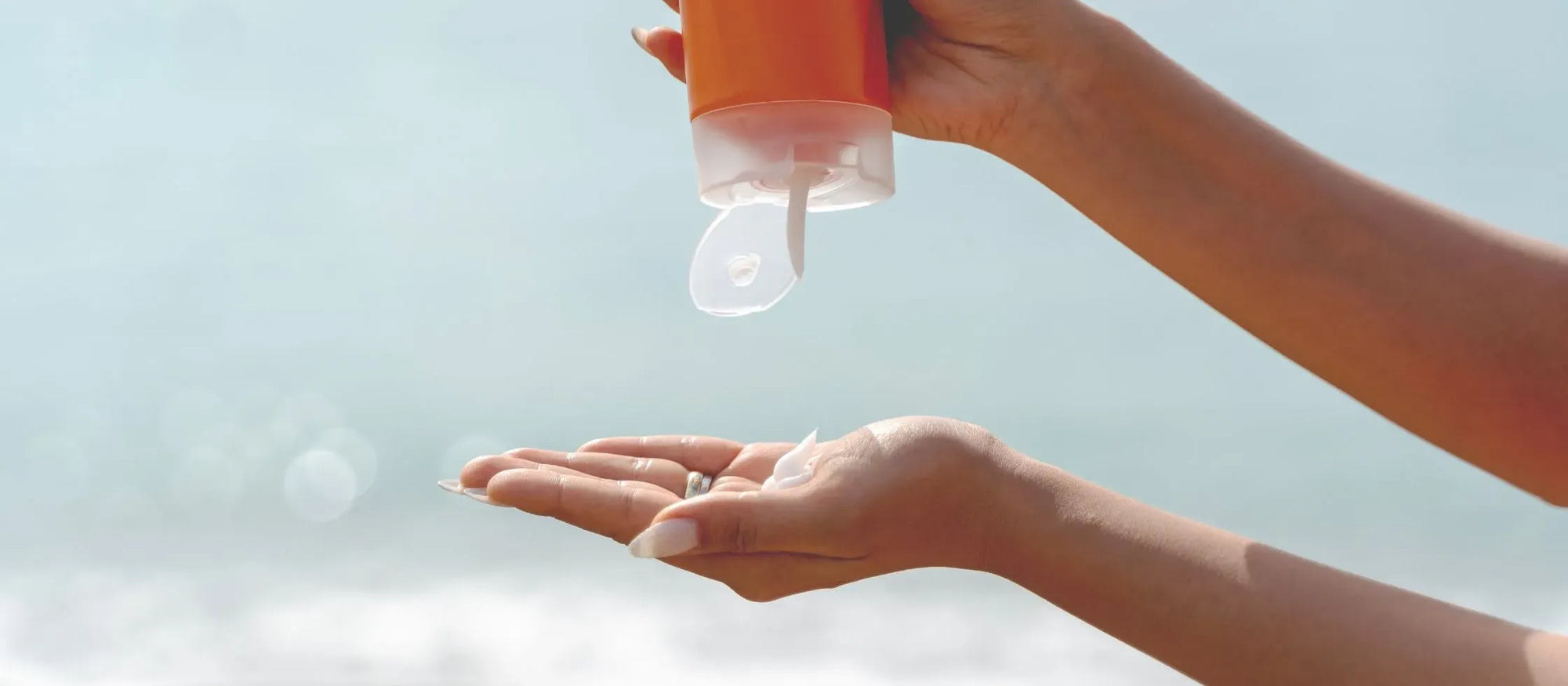 A person applying sunscreen to their skin, highlighting the importance of sun protection for healthy skin.