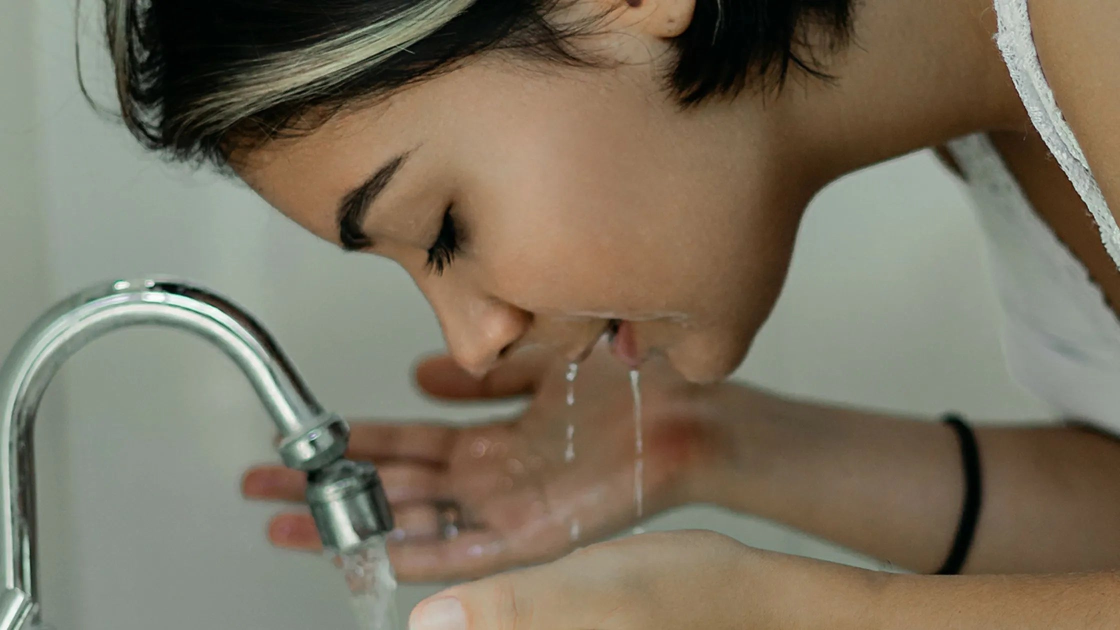 Close-up of a face wash bottle with acne scar removal benefits, surrounded by fresh ingredients and clear skin.