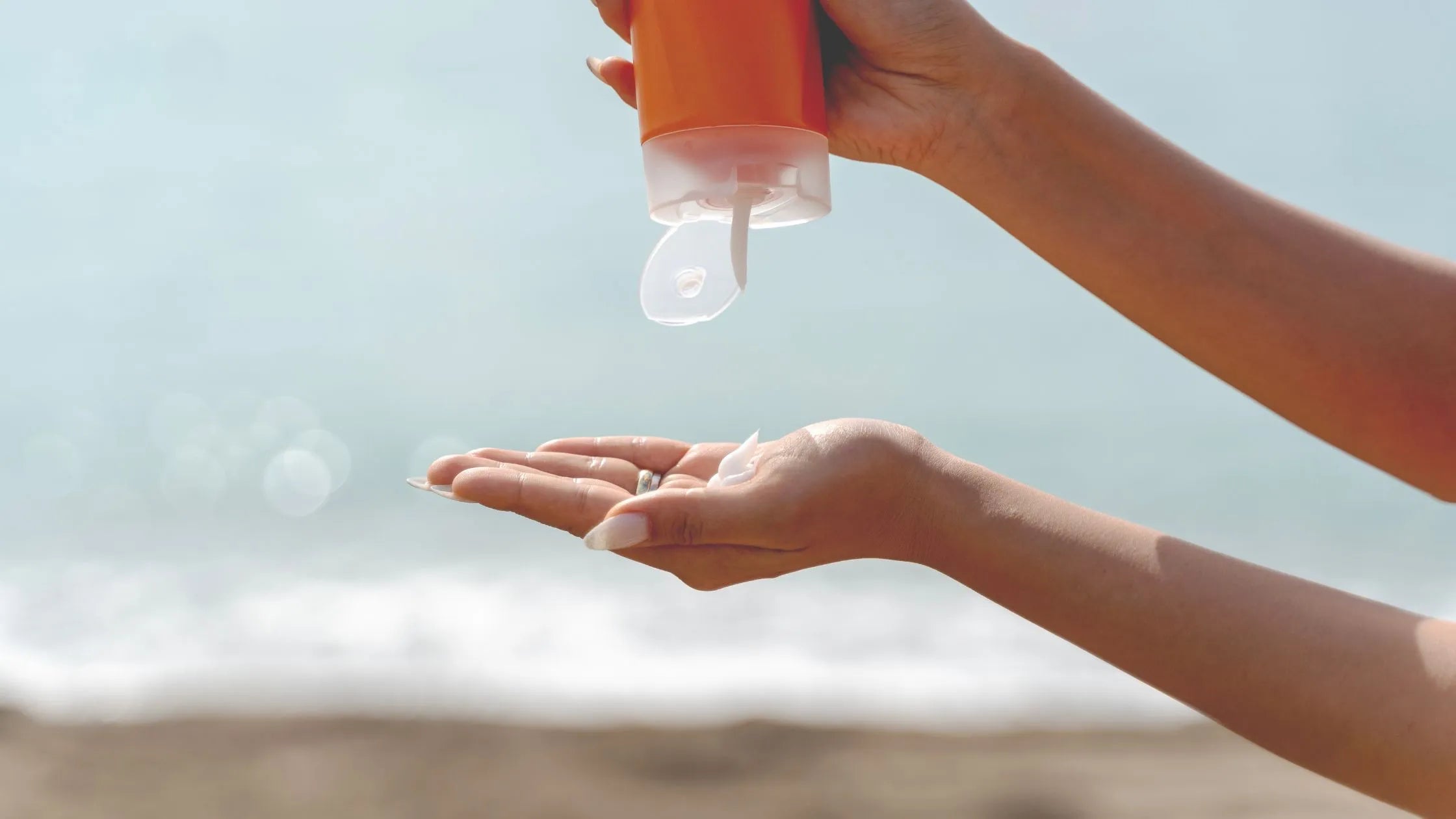 A woman applying tinted sunscreen on her oily skin, showcasing a matte finish and sun protection.