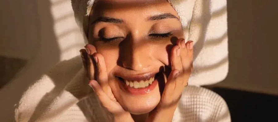 A bottle of sunscreen designed for dry skin, surrounded by moisturizing ingredients like aloe and shea butter.