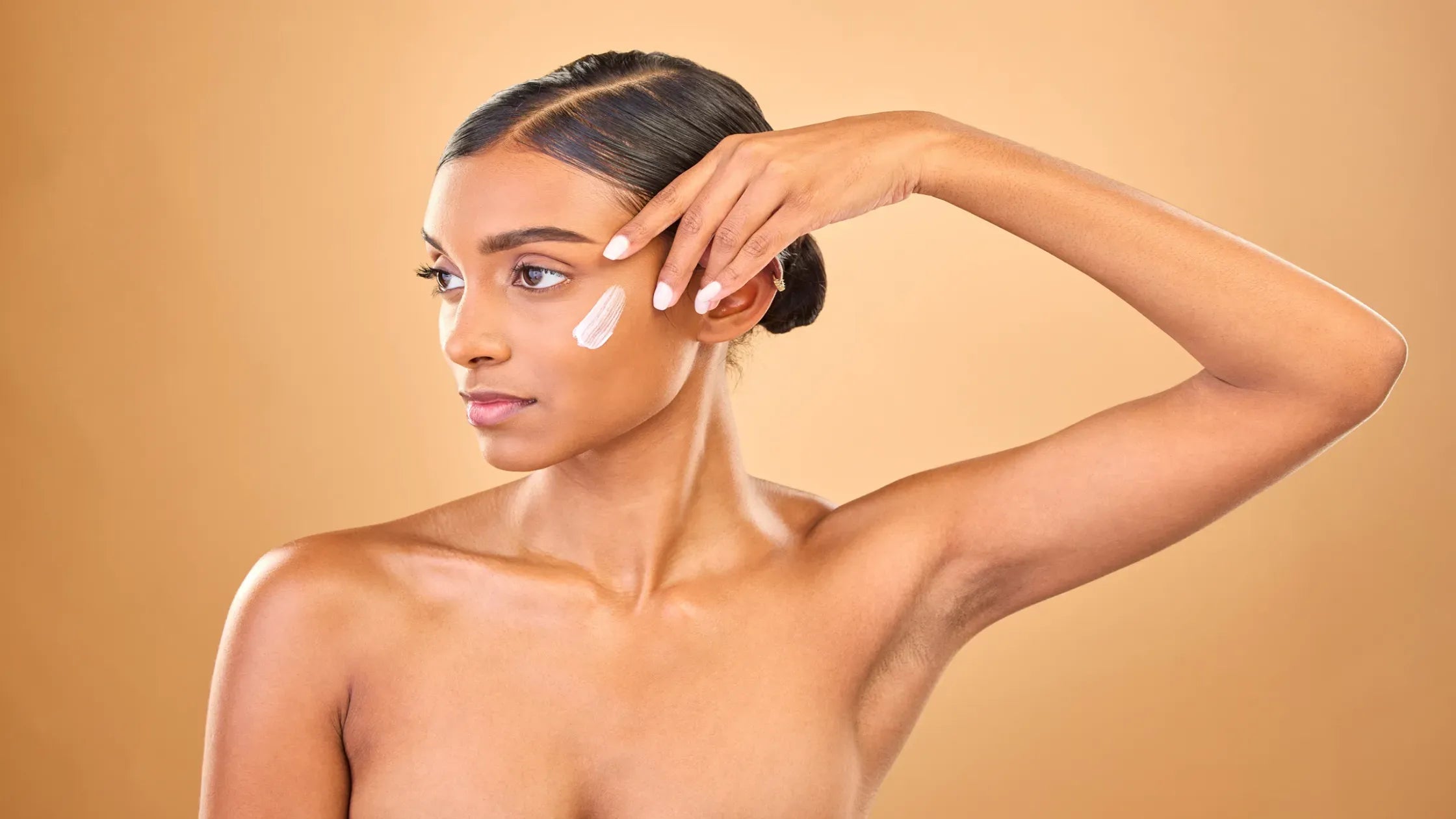 A selection of sunscreens suitable for pigmented skin displayed on a wooden surface in India.